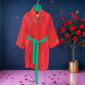Vol IV — The Doll Wall Silk Robe Vol IV — The Doll Wall Silk Robe — scarlet red sheer silk robe with emerald green belt and hanger detail, rose petal editorial backdrop with red rose tree — Golden Expression Art
