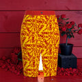 Image 1 (front view — golden yellow pencil skirt, all-over scarlet red ICONIC print, red waistband, front slit, rose petals, red wall backdrop): Golden Expression Art Vol IV The ICONIC Statement Skirt — Front View — Golden Yellow All-Over Scarlet Red ICONIC Print — Red Waistband Front Slit — Rose Petal Red Wall Editorial — ICONIC Edit
