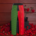 Vol IV — The Royal Play Silk Pants, front view, forest green & black checkered left leg with scarlet red flame panel right leg, black elastic waistband, rose petal editorial — Golden Expression Art
