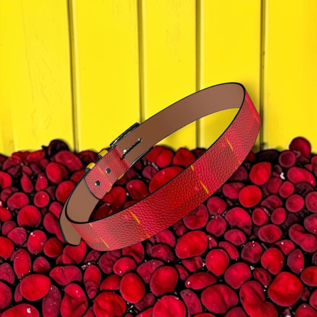 Image 3 — Editorial (yellow wall, red rose petals): Golden Expression Art Vol IV The Scarlet Flame Belt — scarlet red flame-print leather belt styled against golden yellow wall with red rose petals — Stay Golden Edit