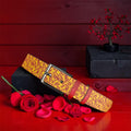 The Golden Decree Belt — golden yellow with scarlet red ICONIC lettering, gunmetal buckle, rose petal editorial