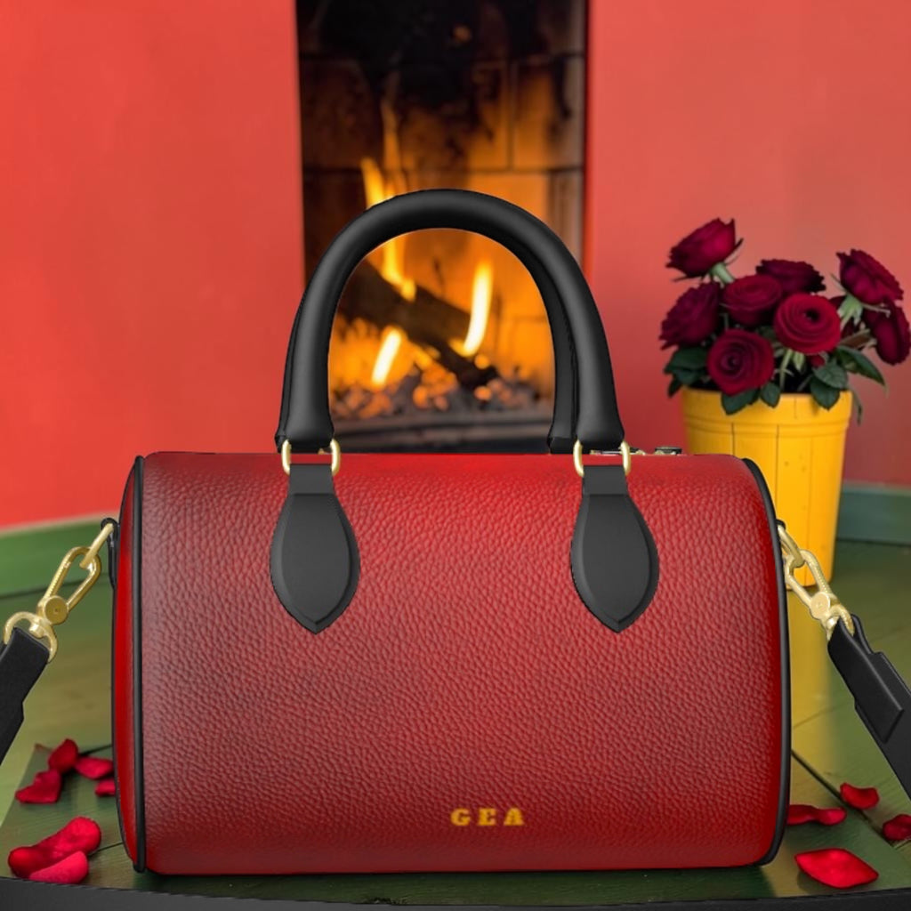Rouge Muse Leather Bowler red back with gold GEA mark, black top handles and shoulder strap.