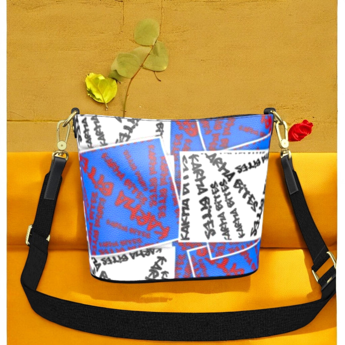Golden Expression Art Vol III Karma Bites Bucket Bag — side view, all-over Karma Bites graffiti script in black, white and scarlet red on cerulean blue, adjustable crossbody strap