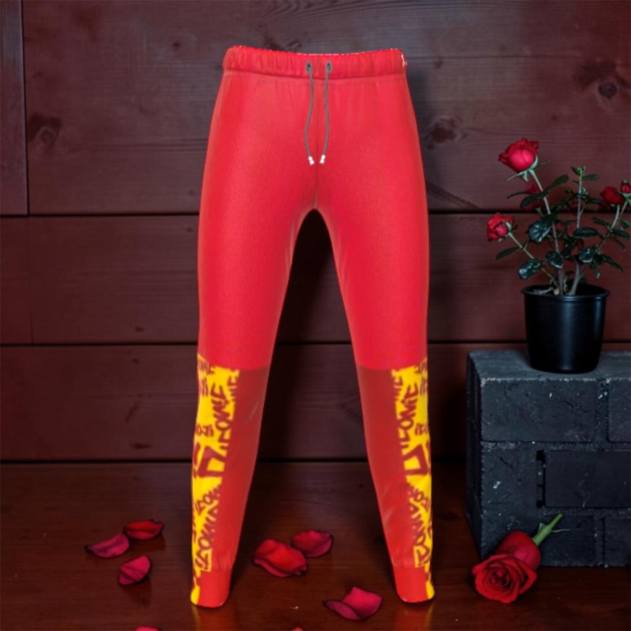 Vol IV The Scarlet ICONIC Jogger — front view, scarlet red tapered jogger with golden ICONIC print at hem, rose petal editorial backdrop
