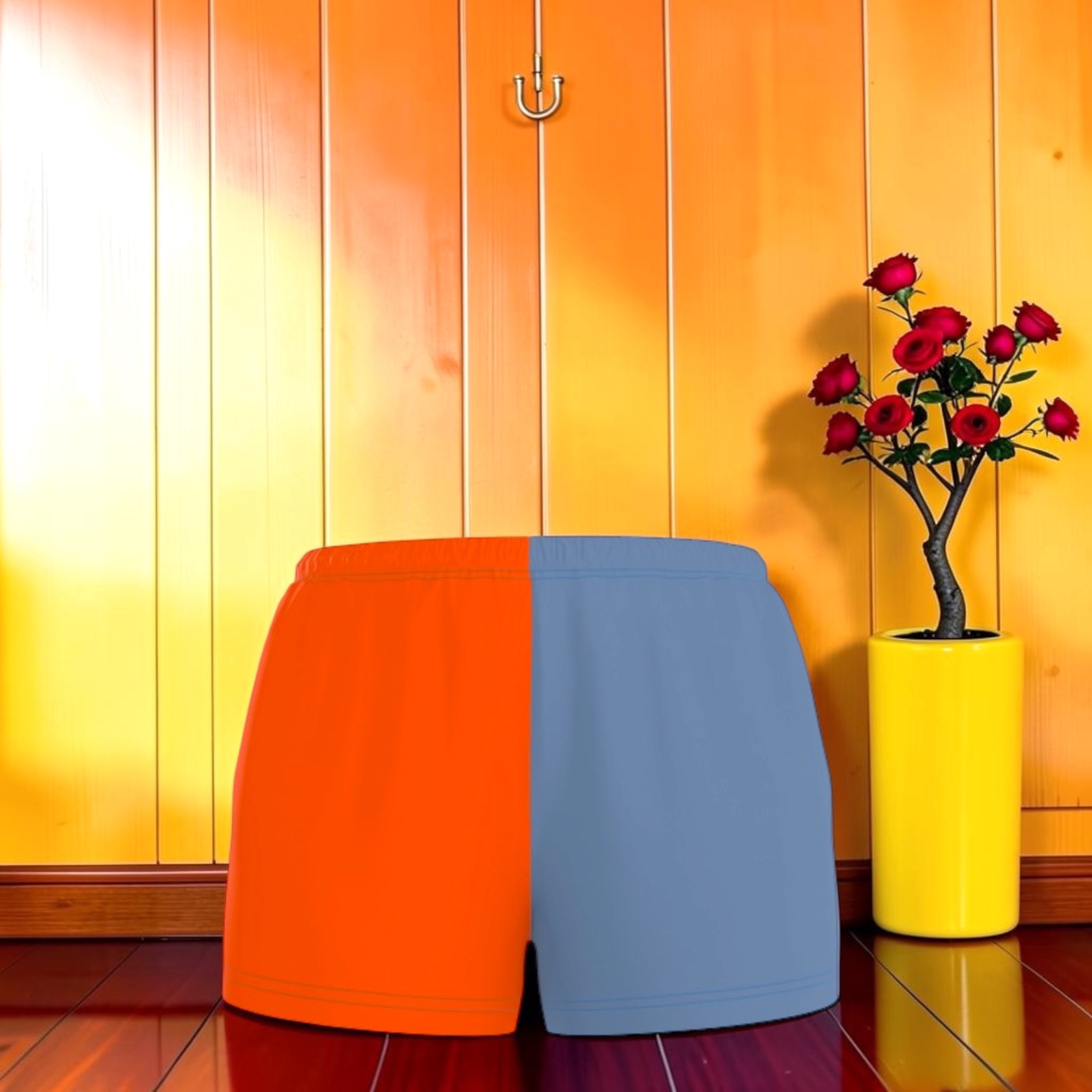 Vol II — The Eden Edit Color-Block Short, front view, orange and slate blue split panel, relaxed short silhouette, orange wall backdrop, GEA