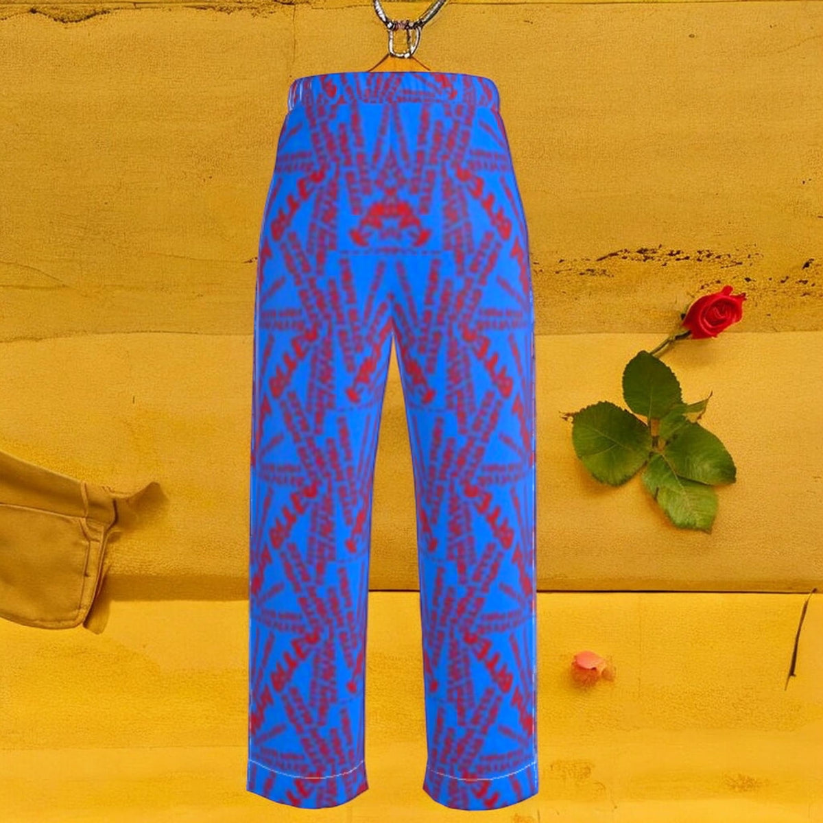 The Unbothered Silk Wide Leg Pant — cerulean blue 100% silk wide leg pant with all-over mirrored scarlet red Karma Bites print, back view styled with red rose on golden yellow backdrop