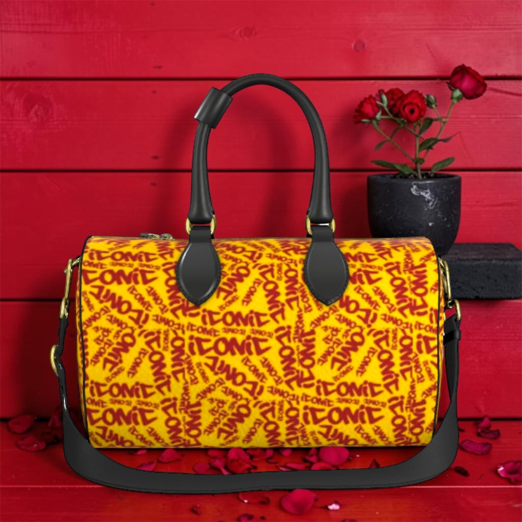 The ICONIC Carry Duffel — front view, ICONIC all-over print in golden yellow and scarlet red, black leather handles, gold hardware, red wall editorial