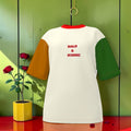 Vol I — The Iconic Statement Tee (Oversized) — Front view: white Nero Ponte body, amber left sleeve, forest green right sleeve, scarlet red collar, BOLD & ICONIC embroidered text on chest