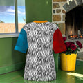 Zebra-print side of oversized T-shirt with blue and red sleeves and golden neckline