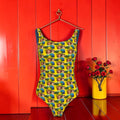 Vol IV The Sun Goddess One-Piece Swimsuit — Front, all-over Doll Wall print on golden yellow