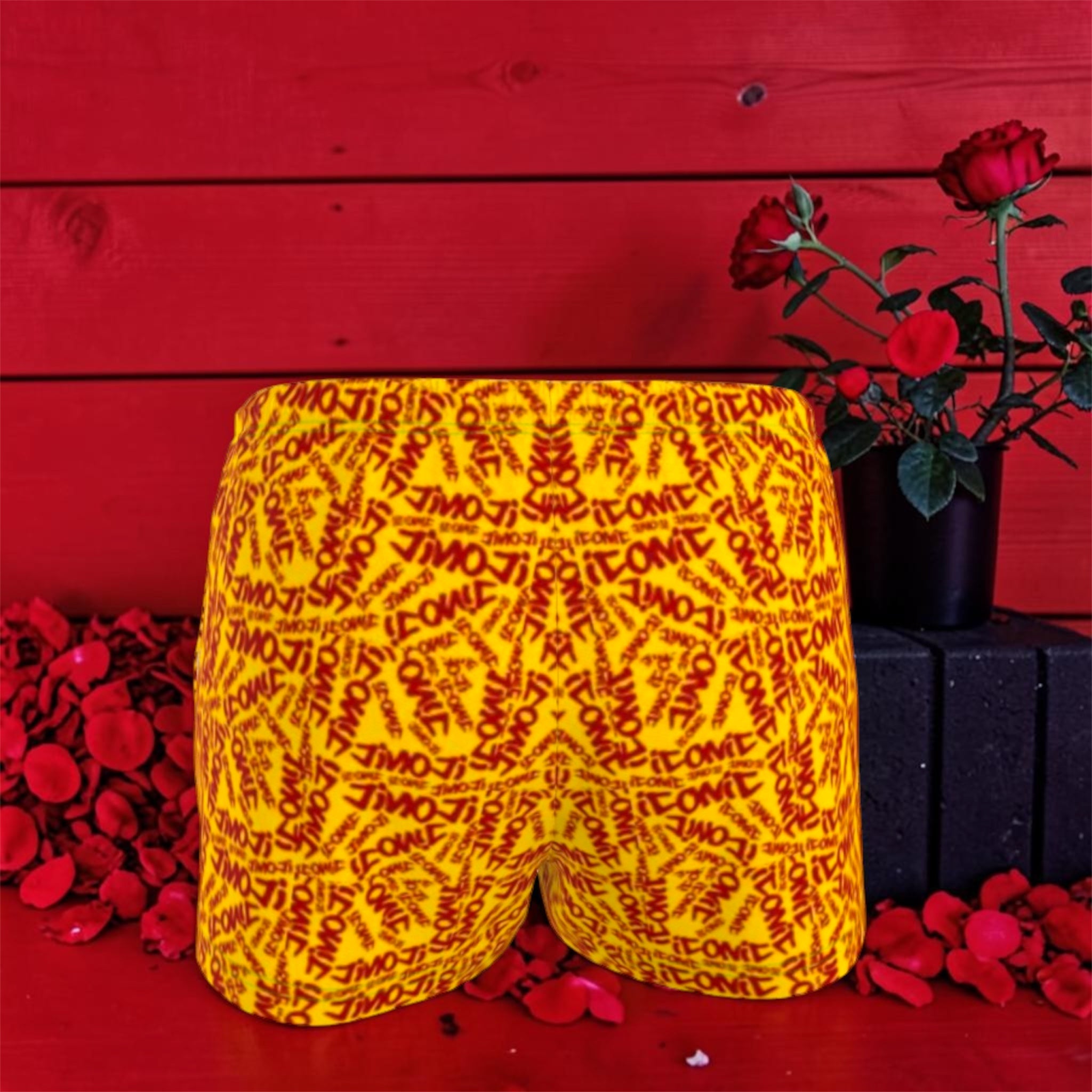 The ICONIC Dream Short — back view, golden yellow ICONIC all-over print, elastic waistband, rose petal editorial backdrop