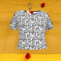 The Karma Bites Crop Tee — front view, all-over black & white Karma Bites graffiti script print with color-block neckline and Checkmate DNA Doll Wall collage sleeves — Vol III The Unbothered Edit by Golden Expression Art