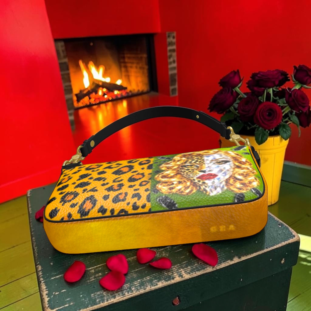Angled view of The Leopard Muse Shoulder Bag showing the leopard and portrait panel and golden-amber base with GEA detail.