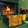 Ember Stripe Leather Clutch front in tiger-stripe print by a lit fireplace with red roses