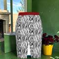 Front view of The Rebel Zebra Denim Midi Skirt with all-over black and white wild stripe print, red waistband, and front center slit