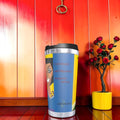 The No Ordinary Sip Travel Tumbler — front view, Doll Wall print with quote detail, red wall backdrop
