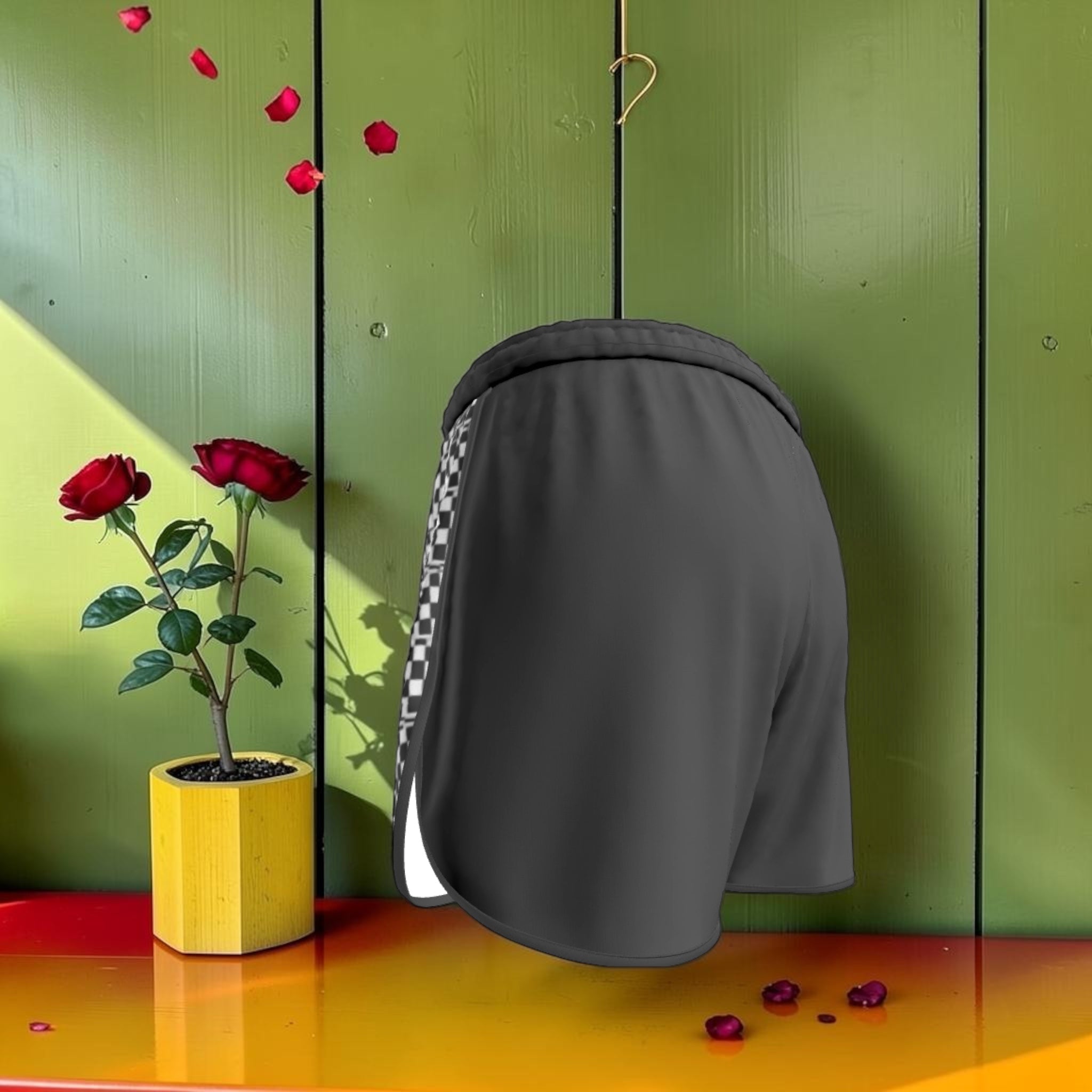 The Half Court Short — back view, solid charcoal with checkered side stripe, green editorial backdrop