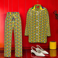 Vol II — The Eden Leisure Set · 100% Silk · All-over Doll Wall print in golden yellow, teal, blue and forest green · Button-down shirt with notched collar and white piping · Matching straight-leg pants · Limited Edition · Golden Expression Art