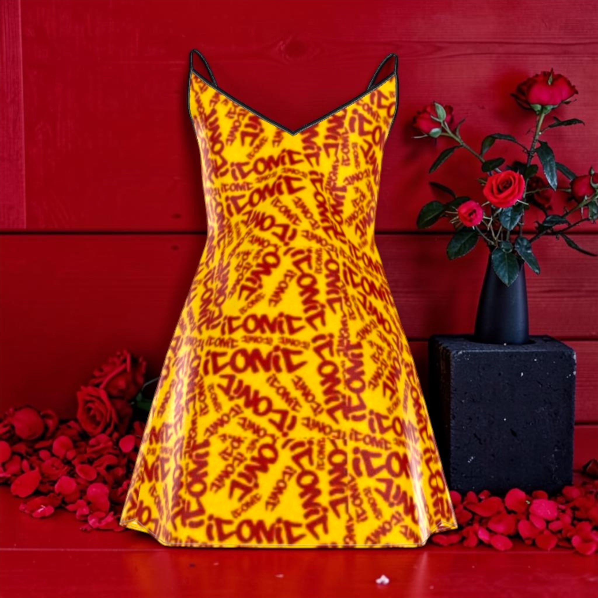 The ICONIC Slip — back view, 100% silk ICONIC print mini dress, flared silhouette, black straps, rose petal and red wall editorial backdrop