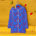 Golden Expression Art Vol III — The Karma Bites Oversized Silk Shirt, front view. Cerulean blue 100% silk with all-over scarlet red Karma Bites starburst print, white contrast piping, silver button-down front, notched collar.
