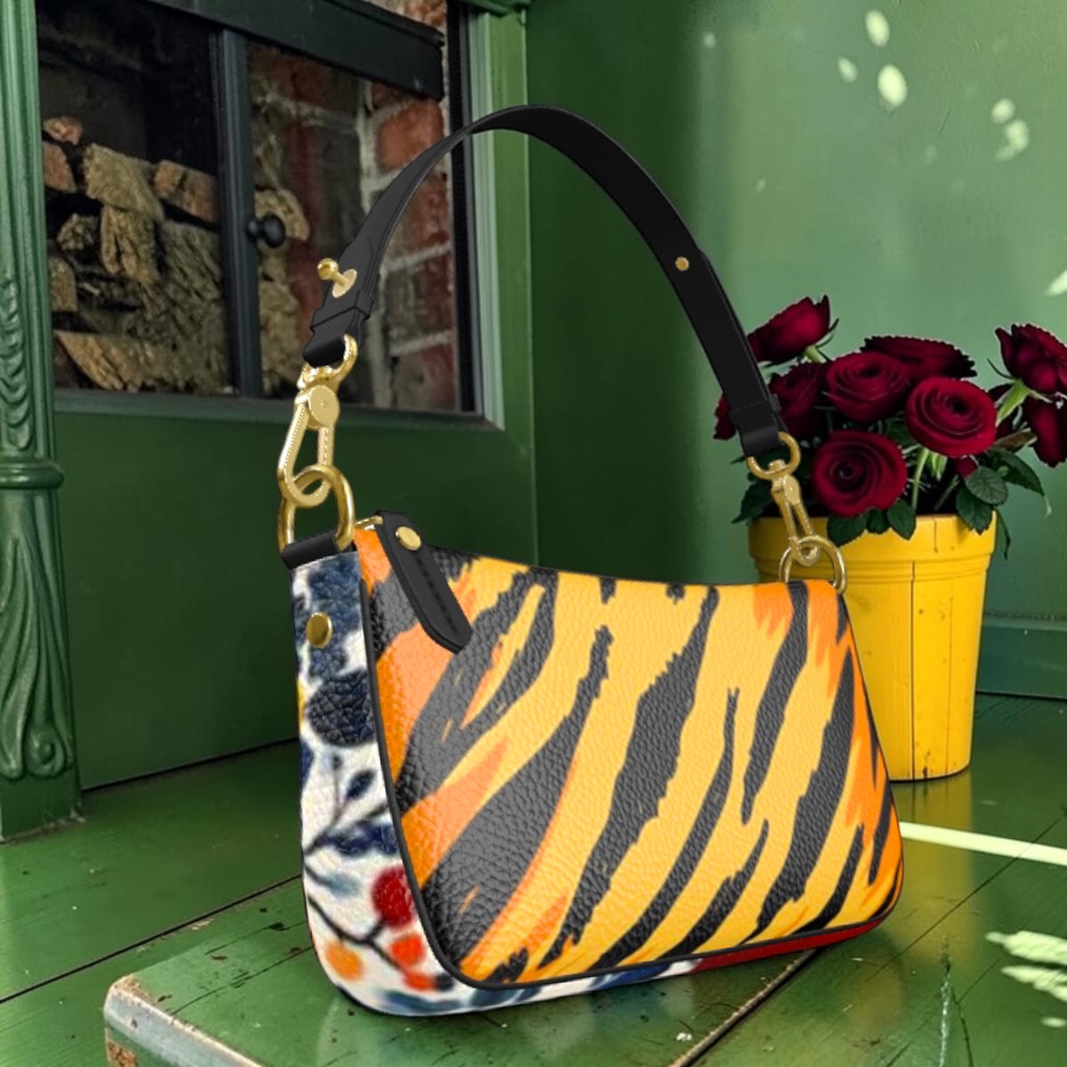 Angled view of tiger-striped shoulder bag showing floral side detail, black strap and gold-tone hardware